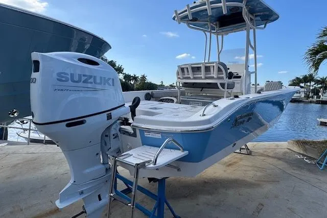 Slide: The Image of 2024 Carolina Skiff 22 Ultra Elite boat with Suzuki outboard motor, docked by the water. - 6