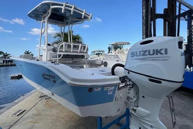 Slide: The Image of 2024 Carolina Skiff 22 Ultra Elite boat with Suzuki outboard motor docked by the water. - 8