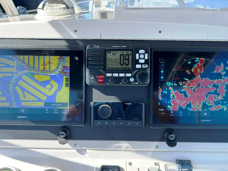 Slide: The Image of 2004 Donzi 35 ZF Cuddy boat dashboard with Garmin navigation displays and radio. - 25