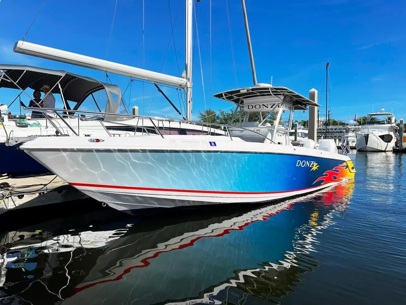 Slide: The Image of 2004 Donzi 35 ZF Cuddy boat with vibrant graphics docked in marina. - 3