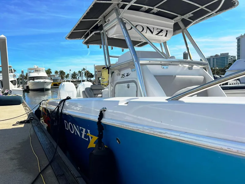 Slide: The Image of 2004 Donzi 35 ZF Cuddy boat docked at marina under clear blue sky. - 31