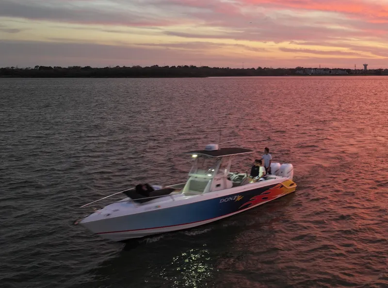 Slide: The Image of 2004 Donzi 35 ZF Cuddy boat cruising at sunset on calm waters. - 38