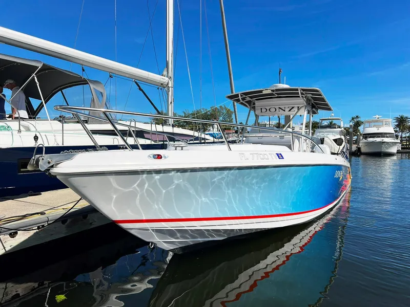 Slide: The Image of 2004 Donzi 35 ZF Cuddy boat docked in marina under clear blue sky. - 4