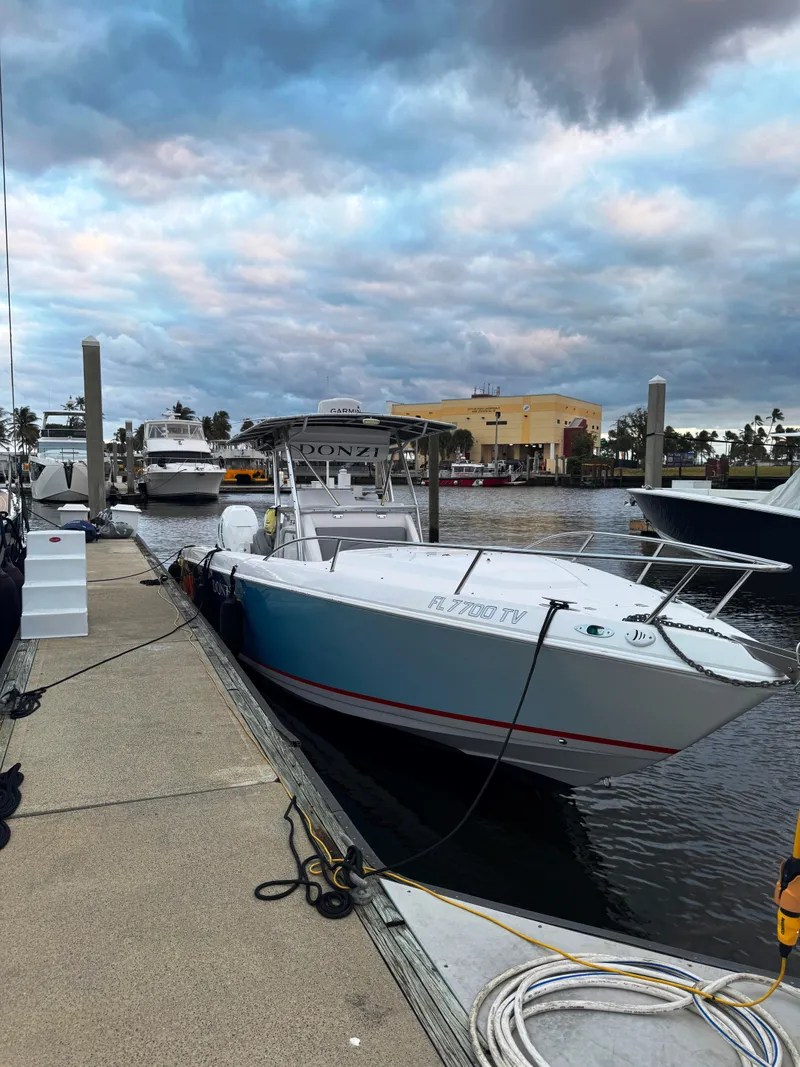 Slide: The Image of 2004 Donzi 35 ZF Cuddy boat docked at marina under cloudy sky. - 7
