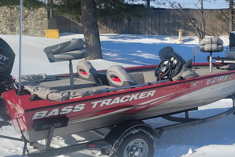 The Image of 2013 Tracker Pro Team 175 TXW bass boat on snowy ground, red and silver design. - 0