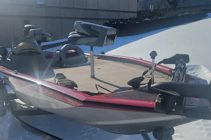 Slide: The Image of 2013 Tracker Pro Team 175 TXW boat on snowy ground, featuring red and gray design. - 2