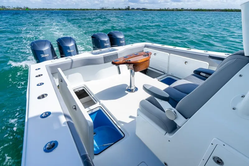 Slide: The Image of 2018 Freeman 37VH boat interior with seating, table, and four outboard engines on the water. - 37