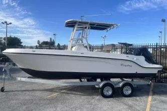 Slide: The Image of 2022 Trophy T22 boat on trailer, parked outdoors under blue sky. - 6