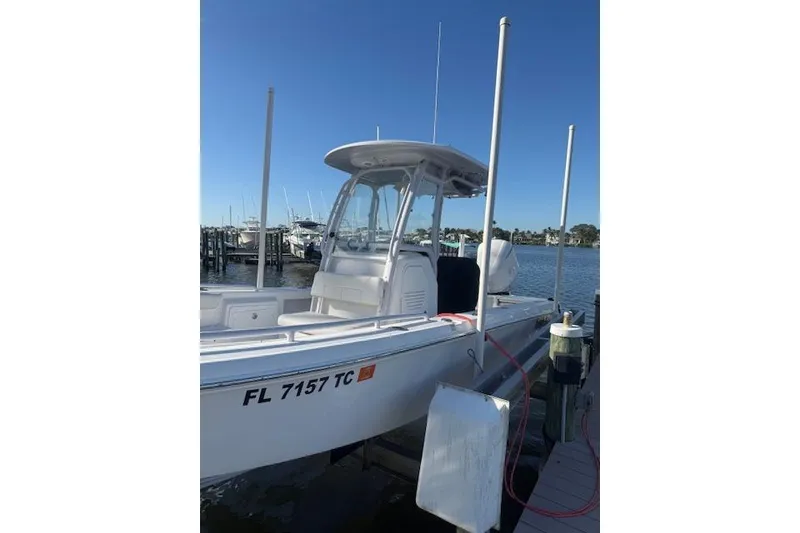Slide: The Image of 2021 Everglades 243 Center Console boat docked at marina under clear blue sky. - 20