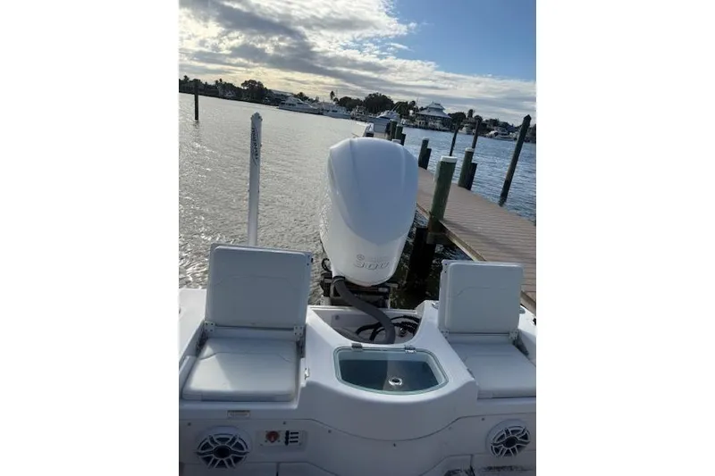 Slide: The Image of 2021 Everglades 243 Center Console boat docked, featuring dual seats and an outboard motor. - 24