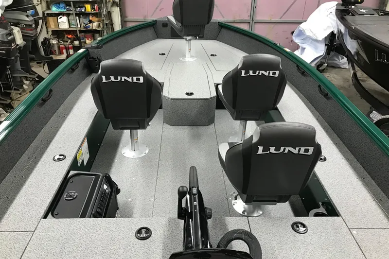 Slide: The Image of 2026 Lund 1700 Explorer Tiller boat interior with four seats in a garage setting. - 17