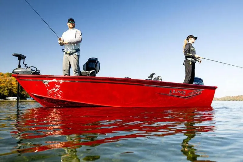 Slide: The Image of 2026 Lund 1700 Explorer Tiller boat in showroom, green exterior, on trailer. - 2