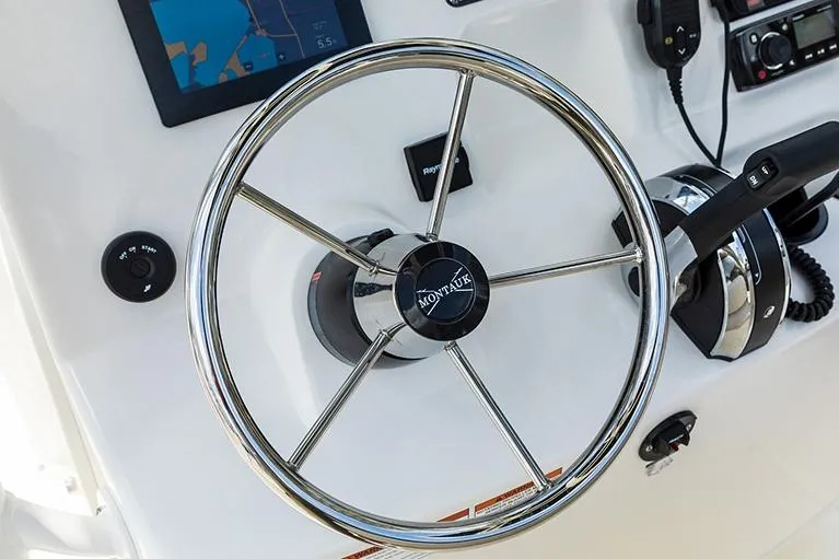 Slide: The Image of Manufacturer Provided Image: Steering wheel of 2026 Boston Whaler 190 Montauk boat with navigation controls. - 9