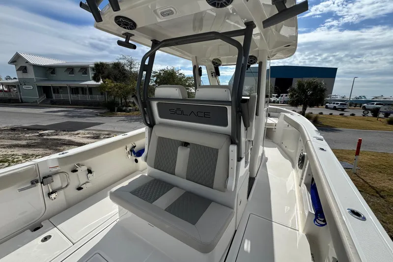 Slide: The Image of 2026 Solace 30 CS boat interior with seating and console, docked near buildings. - 14