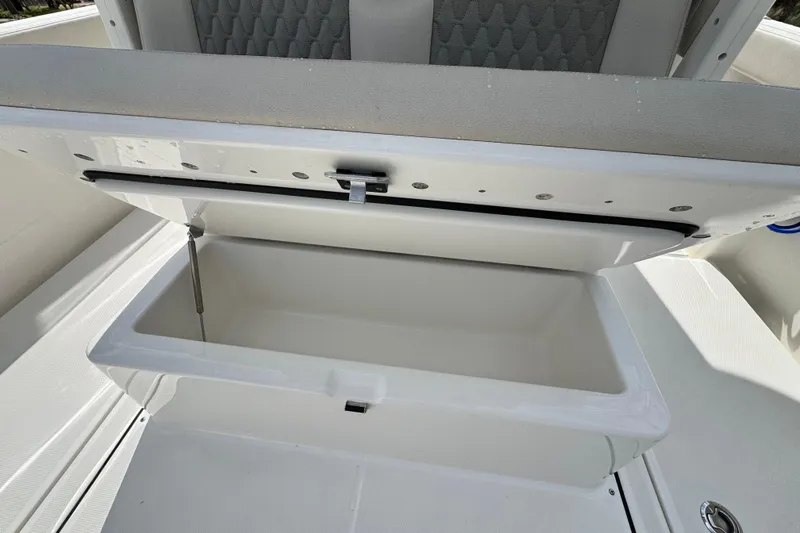 Slide: The Image of Open storage compartment on 2026 Solace 30 CS boat, featuring cushioned seating. - 16