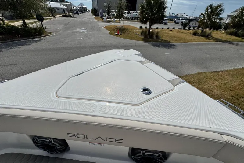 Slide: The Image of 2026 Solace 30 CS boat bow view with logo, parked near marina. - 27