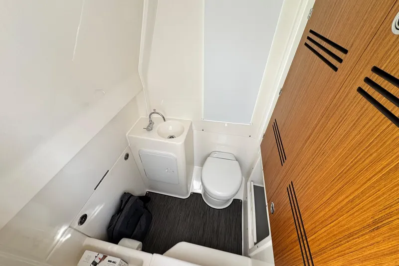 Slide: The Image of Compact bathroom in 2026 Solace 30 CS boat with toilet, sink, and wooden accents. - 29