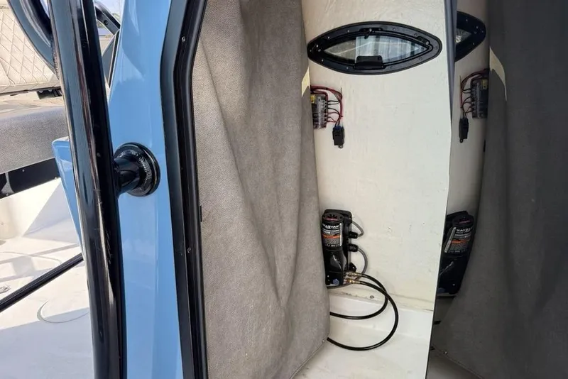 Slide: The Image of 2024 Sea Pro 230 Bay interior storage compartment with wiring and equipment. - 15