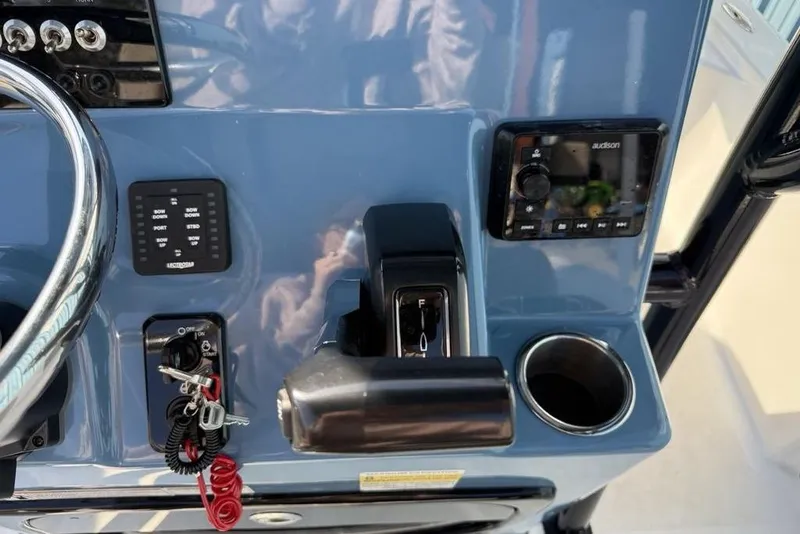 Slide: The Image of 2024 Sea Pro 230 Bay boat dashboard with controls and cup holder. - 16