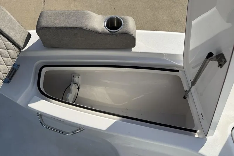 Slide: The Image of 2024 Sea Pro 230 Bay boat storage compartment with cushioned seat and cup holder. - 19