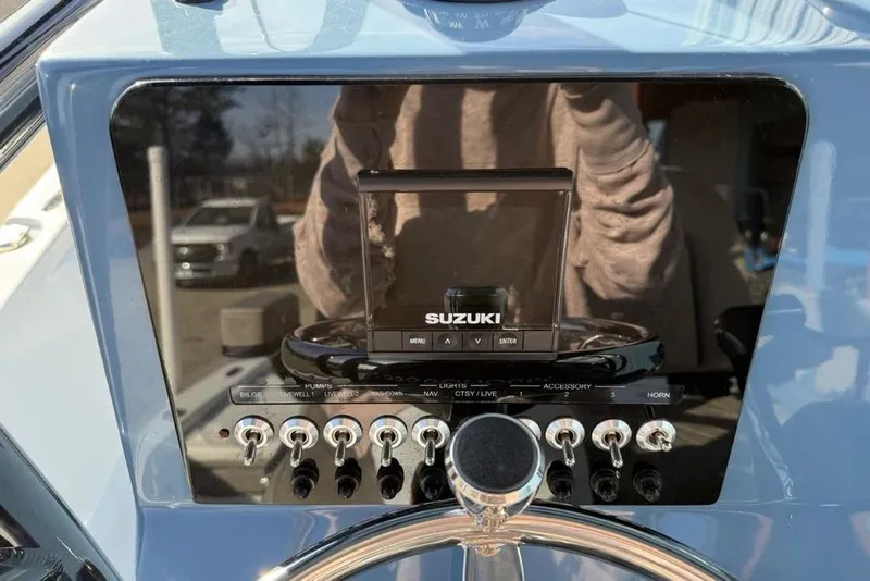 Slide: The Image of 2024 Sea Pro 230 Bay dashboard with Suzuki controls and switches. - 23