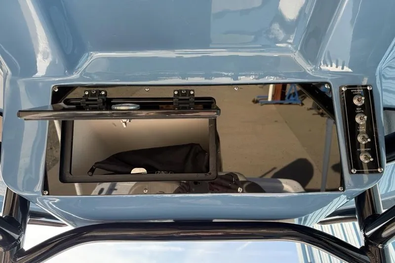 Slide: The Image of 2024 Sea Pro 230 Bay boat console with storage compartment and control switches. - 25