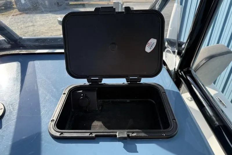 Slide: The Image of Open storage compartment on 2024 Sea Pro 230 Bay boat dashboard. - 29