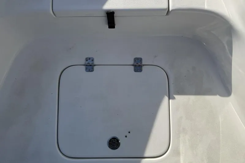 Slide: The Image of 2024 Sea Pro 230 Bay boat storage compartment with secure latch and hinges. - 6