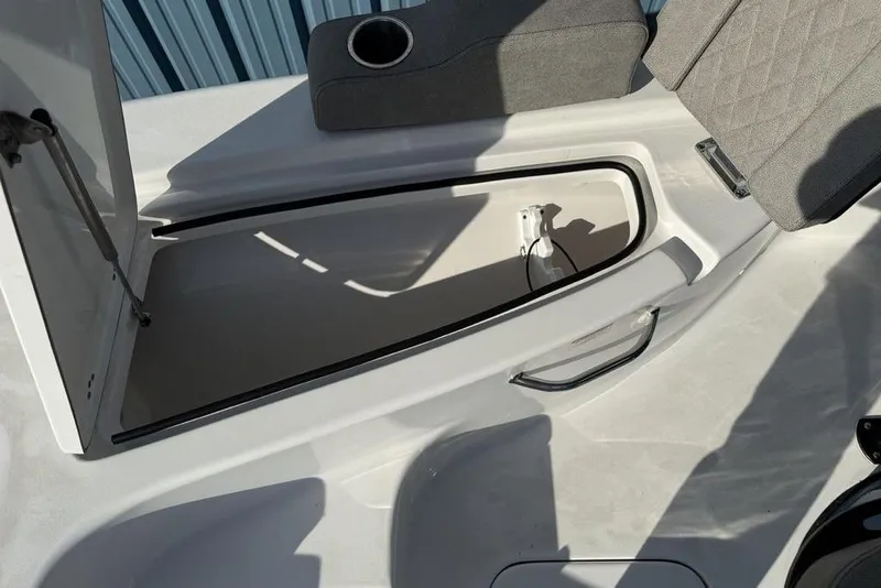 Slide: The Image of 2024 Sea Pro 230 Bay boat storage compartment with open lid and seating area. - 8