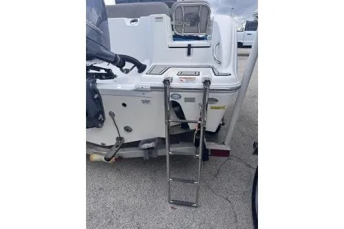 Slide: The Image of 2021 Sea Fox 228 Commander boat with rear ladder and motor, parked on concrete. - 4