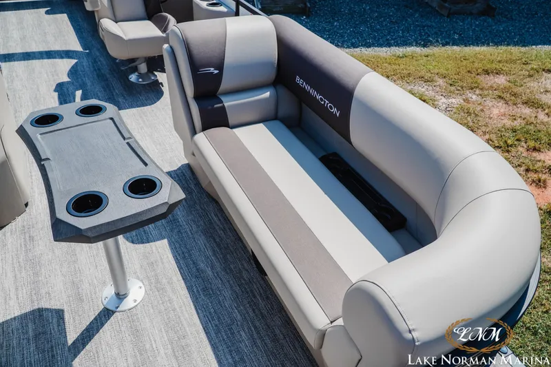 Slide: The Image of 2026 Bennington 22SSR boat interior with plush seating and cupholder table at Lake Norman Marina. - 11