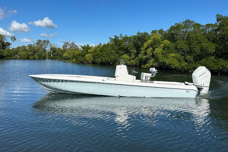 The Image of 2026 Contender 26 Bay boat cruising on a calm river with lush greenery. - 0