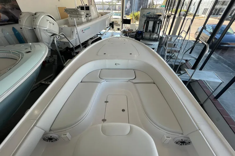 Slide: The Image of 2026 Contender 26 Bay boat interior with white seating and Yamaha engines in showroom. - 12
