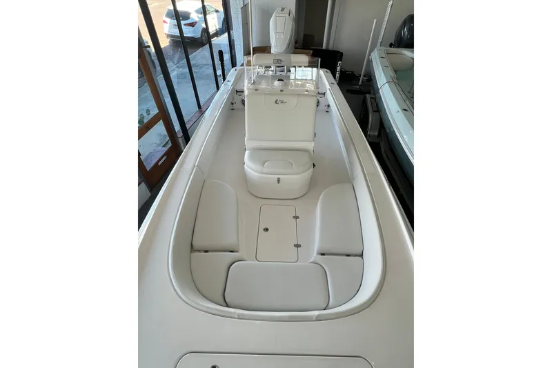 Slide: The Image of 2026 Contender 26 Bay boat interior with white seating and console in showroom. - 13