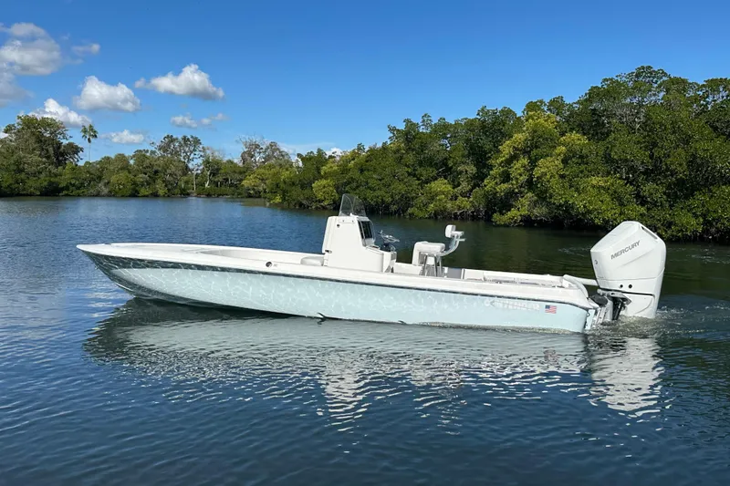 Slide: The Image of 2026 Contender 26 Bay boat cruising on a calm river under a clear blue sky. - 2