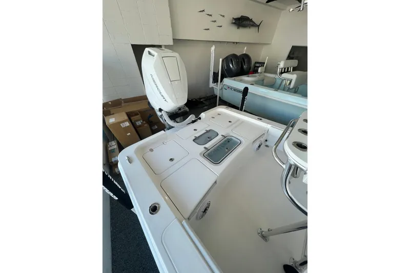 Slide: The Image of 2026 Contender 26 Bay boat interior with Mercury engine in showroom. - 5