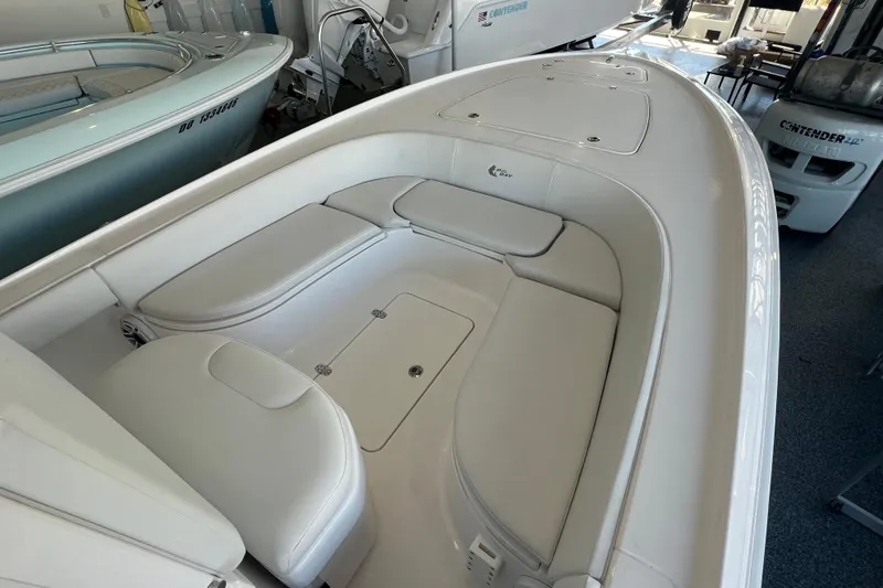 Slide: The Image of 2026 Contender 26 Bay boat interior with white seating and storage compartments. - 9
