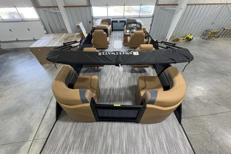 Slide: The Image of 2026 Godfrey Sweetwater 2286 QS pontoon boat with tan seating in a spacious garage. - 30
