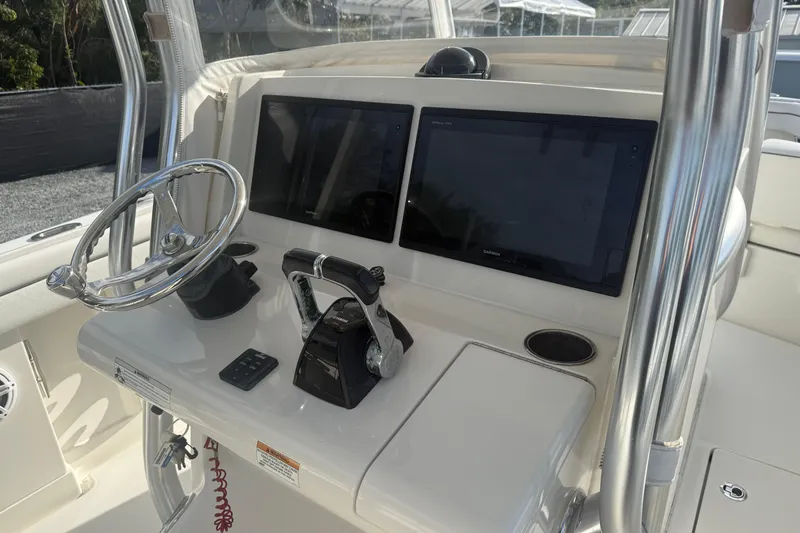 Slide: The Image of Control panel of a 2018 Jupiter 30 boat with dual screens and steering wheel. - 12