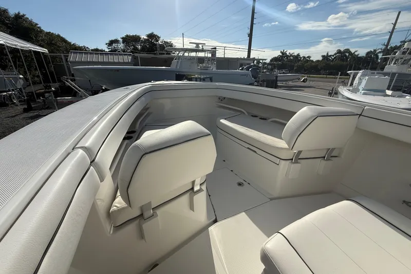 Slide: The Image of 2018 Jupiter 30 boat interior with white seating and sunny outdoor setting. - 18
