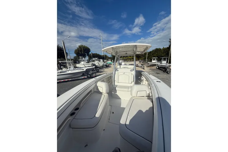 Slide: The Image of 2018 Jupiter 30 boat with spacious seating and canopy, docked under a clear blue sky. - 21
