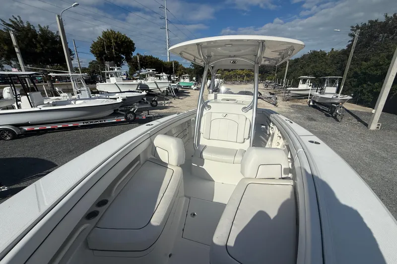 Slide: The Image of 2018 Jupiter 30 boat interior with seating, parked among other boats under a clear sky. - 4