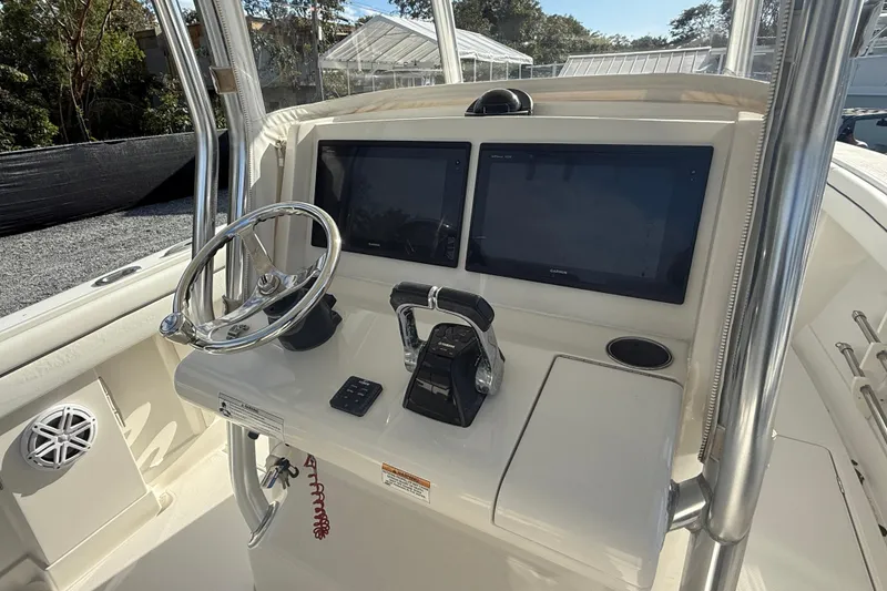 Slide: The Image of Control panel of a 2018 Jupiter 30 boat with dual screens and steering wheel. - 6