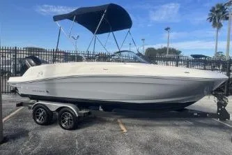 Slide: The Image of 2023 Bayliner VR5 Bowrider OB boat with canopy on trailer, parked outdoors. - 2