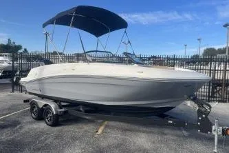 Slide: The Image of 2023 Bayliner VR5 Bowrider OB boat with canopy on trailer, parked outdoors. - 4