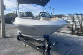 Slide: The Image of 2023 Bayliner VR5 Bowrider OB on trailer, parked outdoors under blue sky. - 5