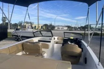 Slide: The Image of 2023 Bayliner VR5 Bowrider OB boat with spacious seating and canopy in a marina setting. - 7