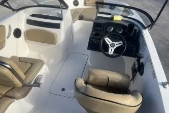 Slide: The Image of 2023 Bayliner VR5 Bowrider OB interior with beige seating and modern dashboard. - 8