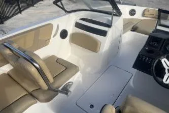 Slide: The Image of 2023 Bayliner VR5 Bowrider OB interior with beige seating and modern dashboard. - 9