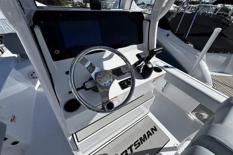 Slide: The Image of 2026 Sportsman Masters 227 Bay Boat helm with steering wheel and controls. - 11